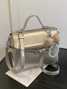 Silver metallic pleated handbag with ribbon charm and top handle crossbody strap