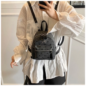 Detail shot of a mini grey backpack with black polka dots and silver bow decoration