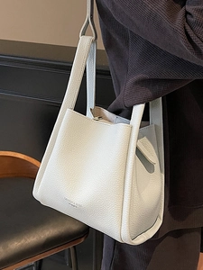 Minimalist beige lychee texture bucket bag with adjustable shoulder strap and fashion logo