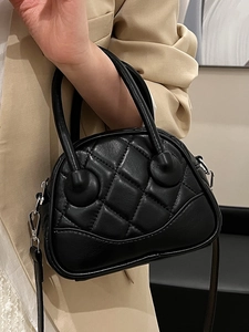 Chic black quilted boston bag with diamond stitching and detachable leather strap