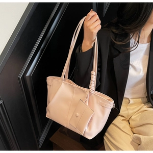 Gros plan d'un sac cabas en cuir rose avec mini pochette accessoire sur la bandoulière