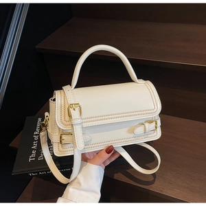 Detail showing white PU leather bag with woven edge and golden buckle hardware decoration