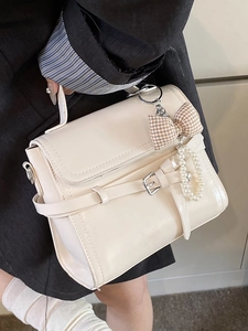 Minimalist creamy white leather tote bag with vintage buckle and pearl bow charm detail