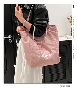 Pink tote bag detail with Our Fave Party text and colorful striped woven handles