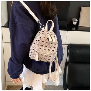 Mini backpack with black bow print and diamond lattice pattern worn by a model