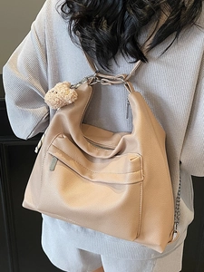 Minimalist apricot pebble leather large tote bag with bear charm on model back view