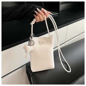 Detail of white PU leather mini crossbody bag featuring an 'm' logo and elephant charm