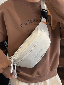 Minimalist beige crossbody chest bag with adjustable strap and brand logo for travel