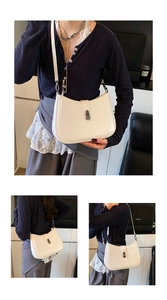 Detail of cream polished leather underarm bag with metal buckle and adjustable strap