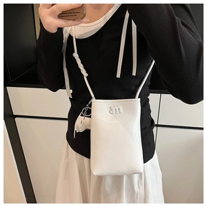 Close-up of white pebble leather crossbody phone bag with m-logo and elephant charm
