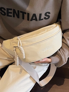 Creamy white minimalist crossbody chest bag with embroidered logo and braided zipper pulls