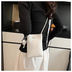 Close-up of a white lychee leather phone crossbody bag with m-embossed detail and horse charm