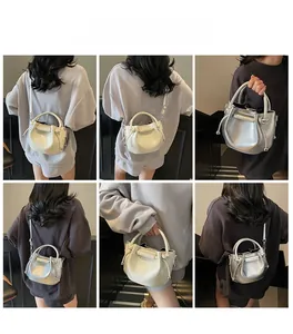 Detailansicht der Mini-Plissee-Beuteltasche in Silber und Off-White am Modell getragen