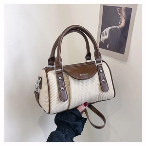 Detail der Boston-Tasche mit beigem Webstoff und braunen Ledernähten am Tragegriff