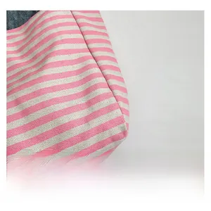 Detail of pink and white striped twill fabric with blue denim lining and reinforced stitching