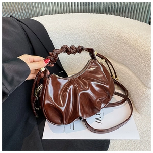 Detailed view of dark brown cloud bag with pleated oil wax leather and smooth metal zipper