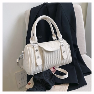 Detailansicht der cremefarbenen Boston-Tasche mit Textur, Nieten und Logo-Prägung