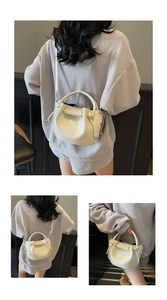 Detailansicht der cremefarbenen Beuteltasche mit Faltenzug und Silberkugel-Deko