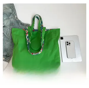 Detailed flat lay of green canvas tote bag showing large capacity and floral handles