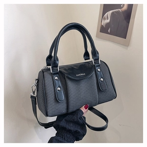 Detail der grauen Webstruktur und schwarzen Leder-Boston-Tasche mit ZHCNMA-Logo und Silberbeschlag