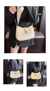 Detail view of cream polished leather underarm bag with dark grey metallic buckle