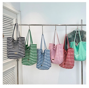 Detail shot of multi-colored striped canvas tote bags with shoulder straps on display