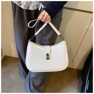 Detail view of white glossy hobo bag with vintage silver metal latch and strap