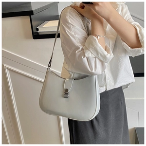 Close-up of minimalist light grey crescent hobo bag with vintage silver metal buckle