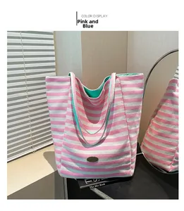 Detail of a pink and blue striped woven tote bag with a handmade metal brand tag