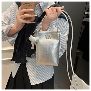 Detail of silver metallic crossbody bag with letter m and cute elephant charm