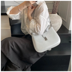 Detailed view of a white minimalist hobo underarm bag featuring a metallic buckle closure