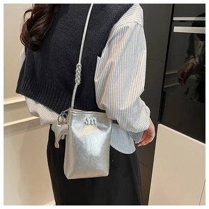 Detail of silver crossbody phone bag with pebble texture and cute elephant charm