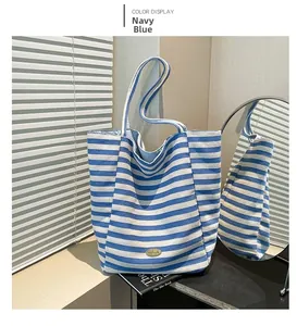 Detailed close-up of navy blue and white striped canvas tote bag with retro oval nameplate