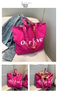 Detail of rose red canvas tote bag with floral handles and Our Five printed lettering