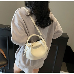 Modell mit cremefarbener Bucket-Bag mit Plissee-Details und verstellbarem Schultergurt