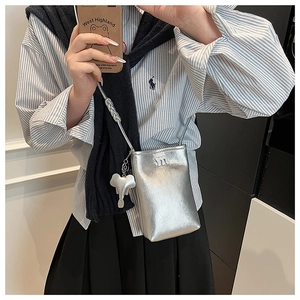 Silver metallic crossbody phone bag with m-logo and elephant charm on striped outfit