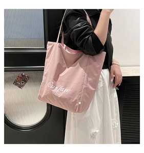 Detailed close-up of a pink canvas tote bag featuring Our fave Party artistic font