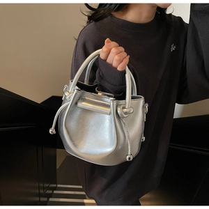 Detail der silbernen Bucket Bag aus Ölwachs-Leder mit Metallic-Finish und Rundgriff