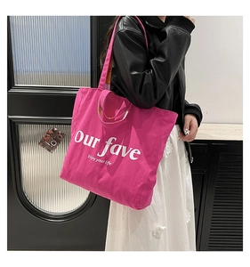 Detailed view of the fuchsia canvas tote bag showing its large size and shoulder strap