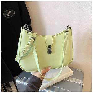 Close-up of minimalist light green leather underarm bag with sleek metal buckle clasp