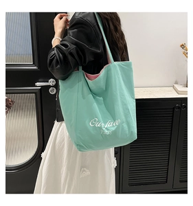 Side view of mint green canvas tote bag with Our fave Party text on a female model