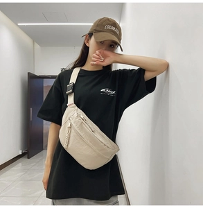 Dettaglio della borsa a tracolla beige minimalista con cinghia regolabile sul modello