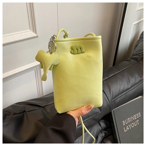 Detail of green mini crossbody bag featuring a 3D letter m and elephant charm