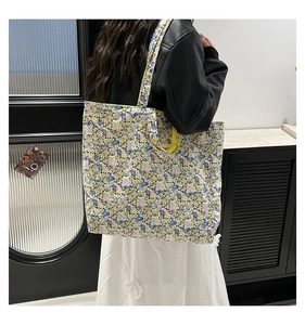 Detail of floral tote bag with yellow handle showing spacious interior and soft fabric texture
