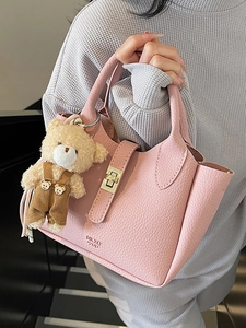 Borsa a secchiello rosa in pelle motivo litchi con ciondolo a orsetto