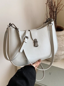 Minimalist white leather crescent underarm bag with silver metal buckle and shoulder strap