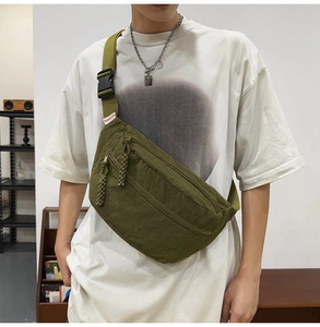 Dettaglio ravvicinato della borsa a tracolla in nylon verde oliva con cerniere ed etichetta