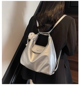 Detail view of silver metallic shoulder bag with white plush chick charm accessory