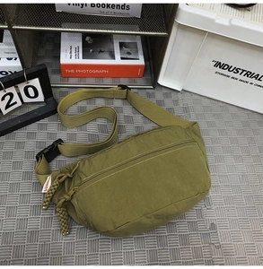 Dettaglio borsa a tracolla in nylon verde oliva con cerniera intrecciata e fibbia nera