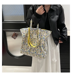 Detailed shot of large capacity floral canvas tote bag with yellow straps and woven patch